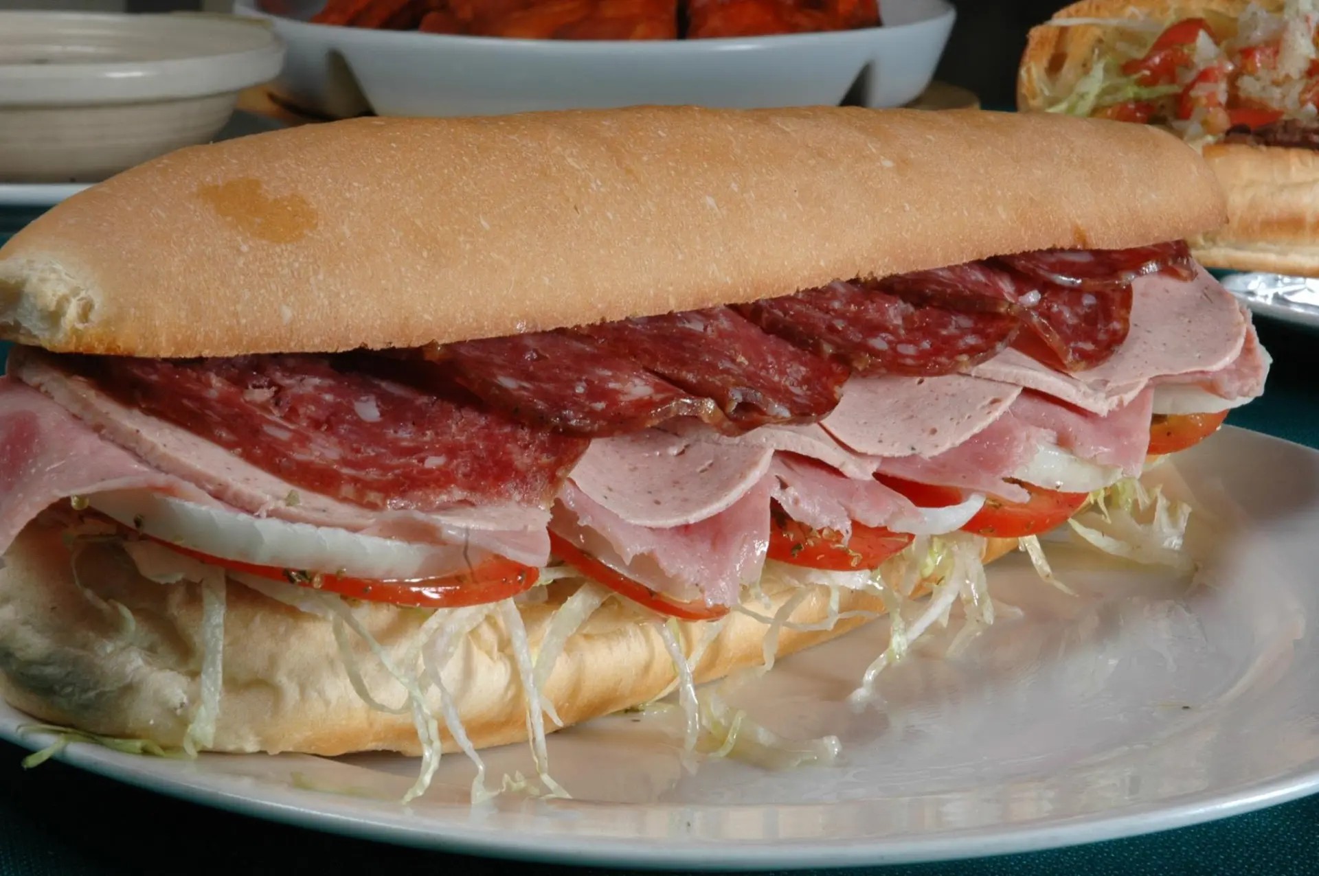 Italian cold cut sub with salami, ham, provolone, tomato, and shredded lettuce