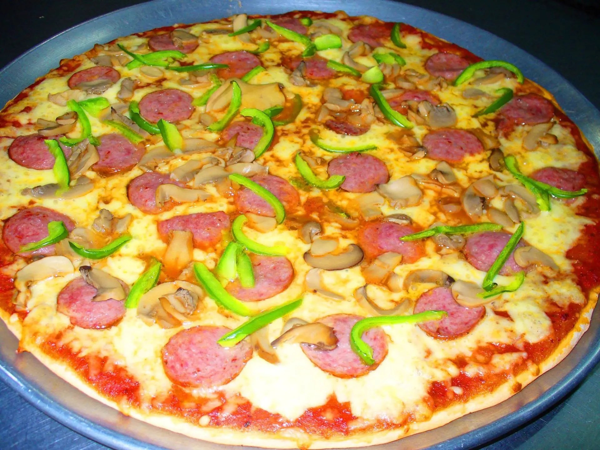 Deluxe pizza with pepperoni, peppers, and mushrooms fresh from our oven